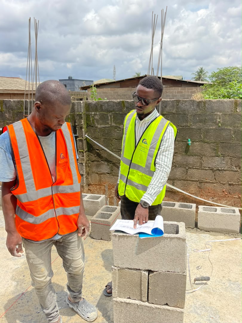 Adolas Construction site team reviewing structural drawings against the blockwork