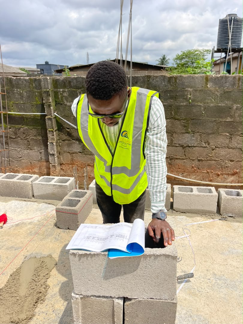 An Adolas Construction site supervisor reviewing structural drawings on-site